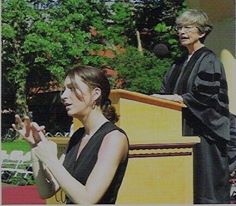 Natalie, interpreting an outdoor college graduation, with the University President at the podium